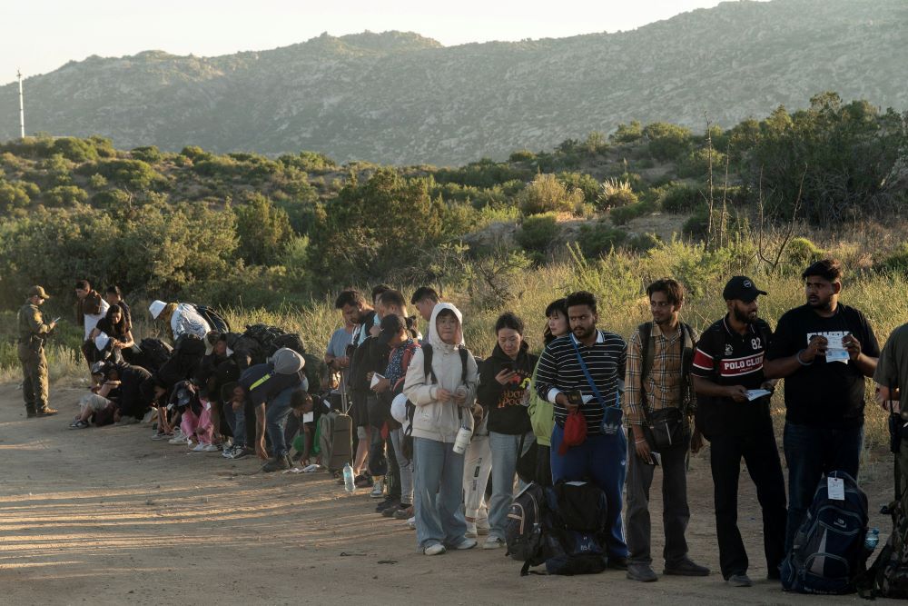 Asylum-seeking migrants stand in line to be transported at a staging area near the border wall, after U.S. President Joe Biden announced a sweeping border security enforcement effort, in Jacumba Hot Springs, California June 5. Asylum-seeking migrants stand in line to be transported at a staging area near the border wall, after U.S. President Joe Biden announced a sweeping border security enforcement effort, in Jacumba Hot Springs, California June 5.
